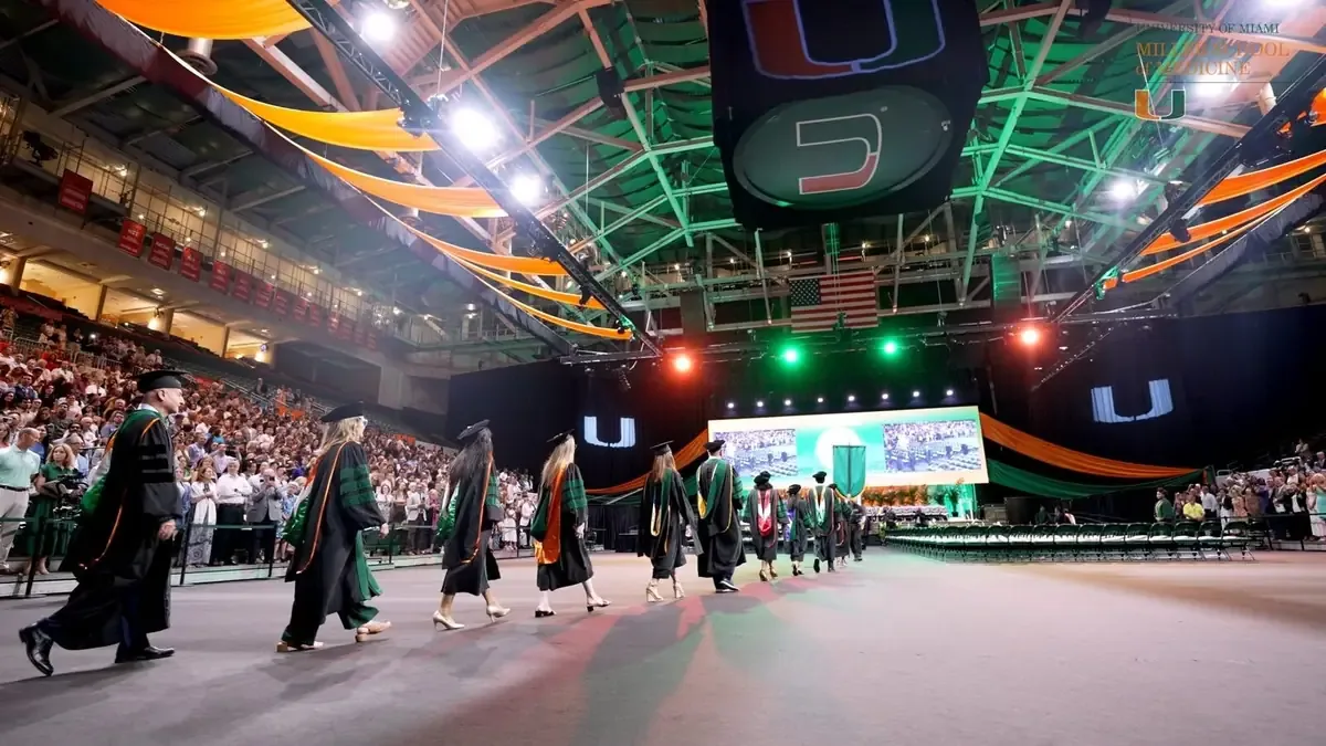 Graduates crossing the arena floor at a University of Miami commencement ceremony